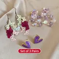 3er-Set Ohrringe mit bunten Schmetterlingen, lila Blumenperlen und Herzsteckern - 925 Silberstift/Legierung/Kristall / Lila/Rosa/Gelb (3-Paar-Set)