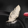Elegant gold feather brooch with zircon stones on a reflective black display stand - Large Size / Gold Large Size