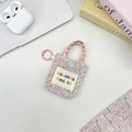 Floral mini pouch with pink handle and clip for earphones or lipsticks on a desk - Colorful Floral