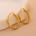 Detail of 18K gold plated hoop earrings with dragon scale texture on white ceramic - Gold 25mm