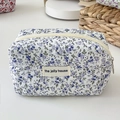 Detailed close-up of lavender floral quilted cotton cosmetic bag with zipper and woven label - Blue Floral