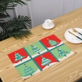 Festive red and green Christmas tree grid placemat shown on a wooden dining table - Christmas Tree