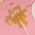 Glittering golden Merry Christmas cake topper with a bow on pink background - Bow Christmas Toppers