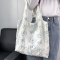 Detailansicht der weißen Canvas-Tasche mit blauen Schmetterlingen und Fransen-Struktur - Cyan Schmetterling Muster Weste Tasche