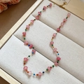 Detail of pink crystal beaded necklace with gold chain on a jewelry display tray - Pink