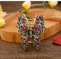 Detailed macro view of vintage bronze butterfly hair claw with enamel flowers and rhinestones - Purple