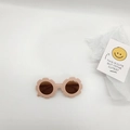 Detail view of retro flower-shaped kids sunglasses in matte nude pink finish - Pink