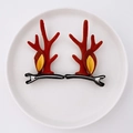 Pair of red reindeer antler hair clips with felt ears on a white ceramic display - 33 Reindeer Antler with Yellow Small Ears Pair