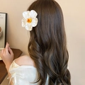 Close-up of a white hibiscus hair clip with yellow pistil worn on wavy brown hair - 19# Duckbill Clip - Pure White Artificial Flower Style