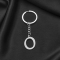 Silver stainless steel keychain with round letter O pendant on dark silk fabric - Letter O