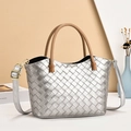 Silberne gewebte Eimertasche mit braunem Griff und Gurt auf minimalistischem Dekor - Silber