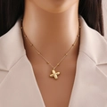 Gold letter necklace with clover pendant and bead chain displayed on mannequin - Letter X