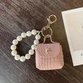 Mini borsa portachiavi in ecopelle rosa cipria con manico in perle e gancio oro - Rosa