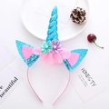 Detail eines blauen Glitzer-Einhornhorns und Stoffblumen auf einem Party-Haarreif - Blaues Einhorn