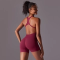 Detail view of burgundy seamless yoga romper showing racerback cutout and ribbed waist - S / Burgundy