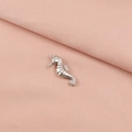 Macro detail of a silver stainless steel seahorse pendant on a soft pink fabric surface - Seahorse (8#)