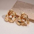Detail shot of golden geometric hollow earrings on beige textured paper and stone - 1# Gold