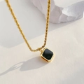 Detail einer Vintage-Goldkette mit einem geometrischen schwarzen Onyx-Anhänger - Quadratisch