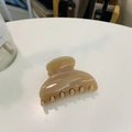 Close-up of a beige polished heart-shaped hair claw clip with teeth on a white table - Approx 6.8cm / Deep Nude Pink
