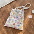 Detail der Netz-Einkaufstasche mit bunten Blumenprints und internem Markenetikett - Schultertasche Stil (Floral)