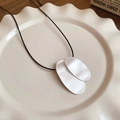 Détail du pendentif en métal géométrique argenté sur un cordon en cuir noir - Style Ovale Argent