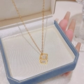 Elegant gold titanium necklace featuring a hollow cube pendant with sparkling zircon stone - Cube (X045) / Gold