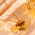 Gros plan d'un pendentif cœur en or 18 carats avec gravure I love you sur du satin - Je t'aime