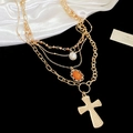 Macro detail of layered gold necklace with white pearl, orange gem and cross pendant - Gold (4-Piece Set)