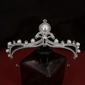 Elegant silver bridal crown with pearls and rhinestones displayed on a dark bottle - Style HG-082 Large