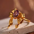 Macro shot of bow knot ring with teardrop purple amethyst and textured gold finish - 3D Bowknot Design (LR189)