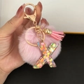Detail of pink faux fur pompom and letter X resin keychain with heart sequins - Letter X