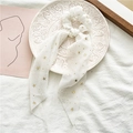 Détail d'un chouchou en mousseline blanche avec rubans et étoiles sur une assiette blanche - Blanc Cassé Avec Étoiles Dorées