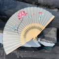 Silk folding fan with pink lotus hand embroidery and green tassel on bamboo ribs - Lotus