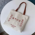 Detail of canvas tote bag with red inspirational text and brown handle for students - Success in Exams