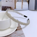 Detail of beaded braided headband with pearls on white ceramic plate for elegant hair styling - Silver