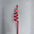 Detailed close-up of a red spiral plastic straw featuring a glittery cherry pendant - Cherry