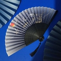 Detail of blue crane fan with red sun pattern, black frame and elegant tassel - Black Red Sun Crane