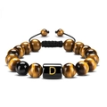 Macro detail of 10mm tiger eye stone beads and golden letter D on woven bracelet - Letter D