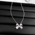 Close-up of pink zircon bow necklace with silver pendant on black textured leather - Silver Bowknot