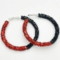 Macro shot of large hoop earrings featuring red and black glitter texture for sports fans - Red and Black