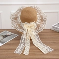 Natural straw sun hat featuring white lace trim and elegant long ribbon streamers - Lace Knot Khaki