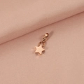 Macro shot of rose gold star pendant with lobster clasp on pink textured fabric - Rose Gold