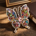Broche papillon vintage élégante avec cristaux colorés sur un bureau en bois - Multicolore