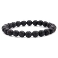 Detailopname van de poreuze textuur van 8mm zwarte lavasteenkralen op elastische armband - Lavasteen