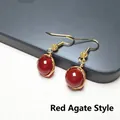 Detailed macro view of red agate earrings with handmade gold wire wrapping and hooks - Red Agate Pair