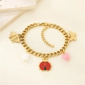 Pulsera dorada con dijes de abeja, mariquita, corazón y mariposa sobre fondo beige - Mezcla de mariposa y corazón (KB206900-SXSJ)