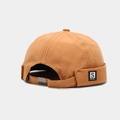 Detalle de la hebilla metálica ajustable y la etiqueta en el gorro Miki marrón - Naranja