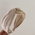 Close-up of light beige fabric headband with frayed edges and twist knot detail - Milk Tea