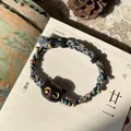 Handwoven friendship bracelet featuring a cute black cat bead and golden accents - Double Woven Yellow Eye Cat
