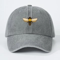 Close-up detail of a dark gray washed cotton baseball cap with a colorful bee embroidery - One Size / Gray